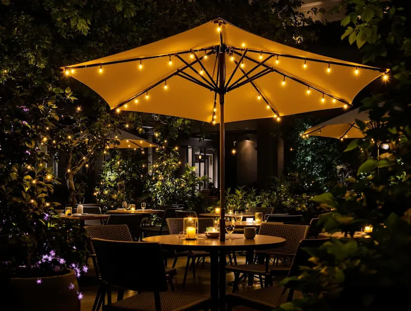 Solar lighted umbrella creating magical ambiance for evening outdoor dining experience