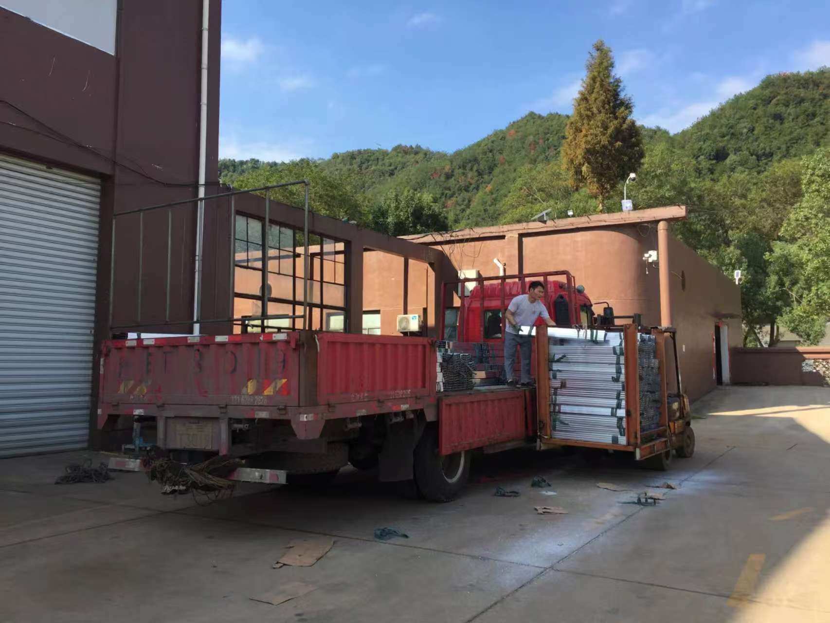 A factory worker efficiently loading outdoor furniture for shipping.